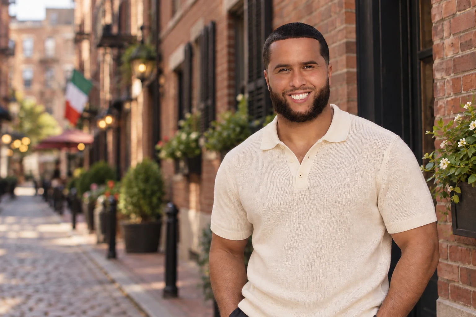 C-Money outdoors in a cream knit polo.